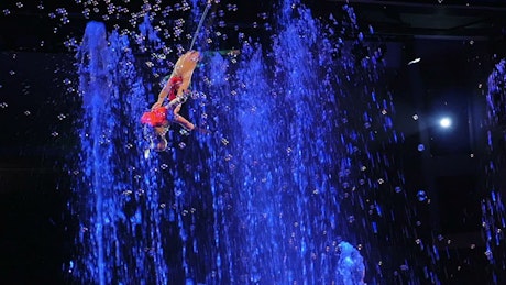 Acrobats performing above fountains.