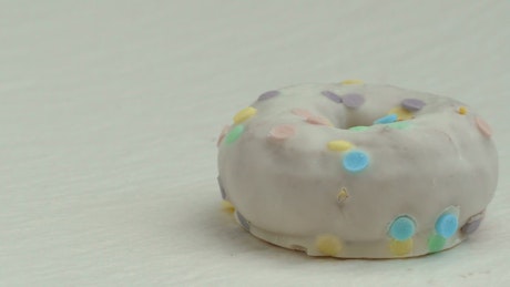 Adding candy to a donut.