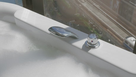 Adding hot water to a bath