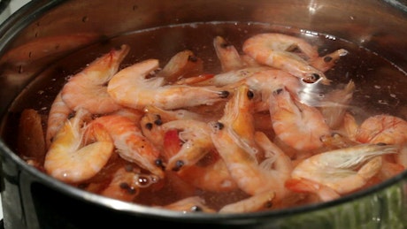 Adding shrimp to a pan.