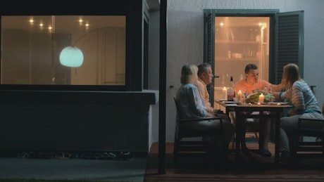Adults eating dinner by candlelight
