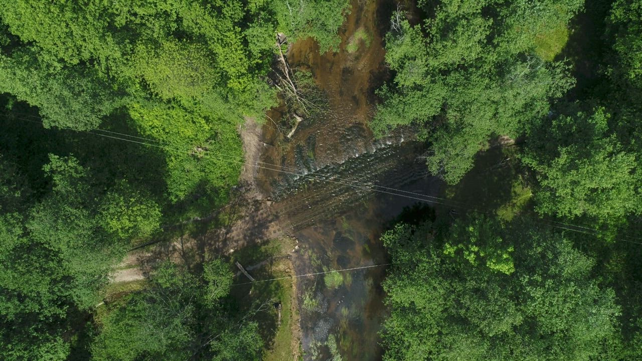 Aerial rotating view of jeep c live draw super wuhan rossing river in jungle