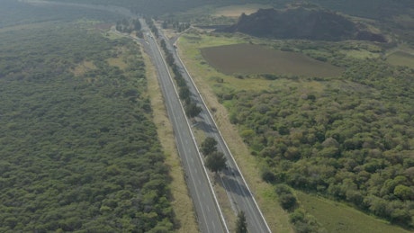 Aerial shot of a highway in nature.