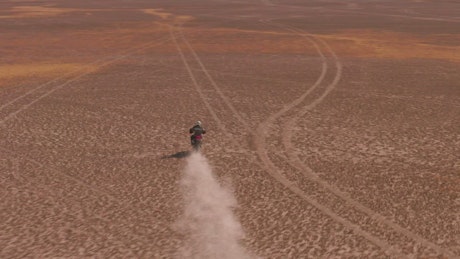 Aerial shot of a motorcyclist in the desert.