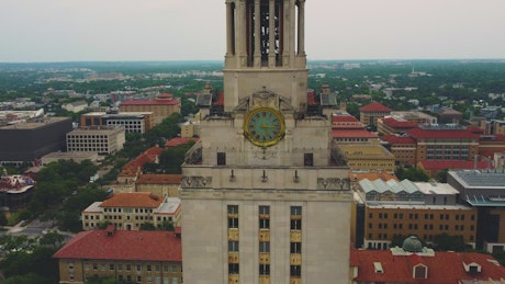 Aerial shot of a tower with a clock in a city.