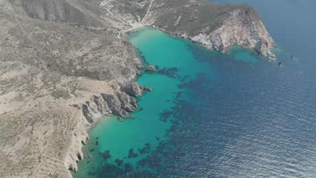 Aerial view of a bay with crystal clear blue water.