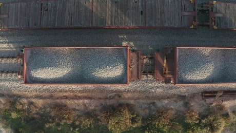 Aerial view of a freight train filled with gravel ready for transport.