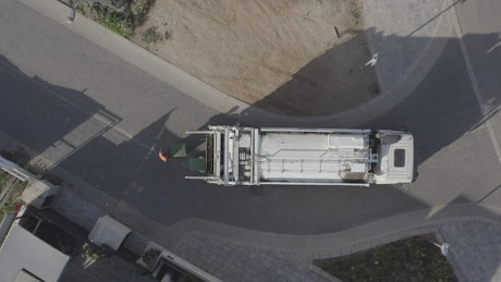 Aerial view of a garbage truck removing rubbish from a suburban street.