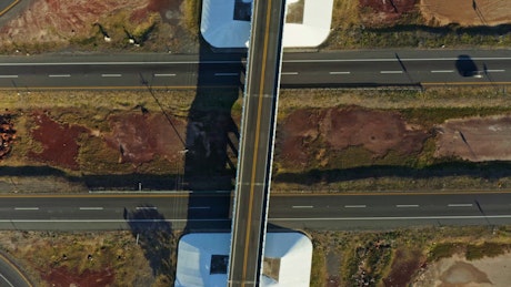 Aerial view of a highway crossing with transport vehicles moving on a sunny day.