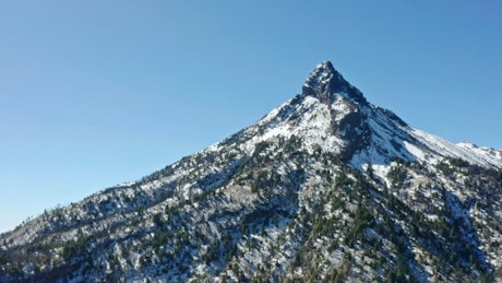 Aerial view of a large snowy mountain.