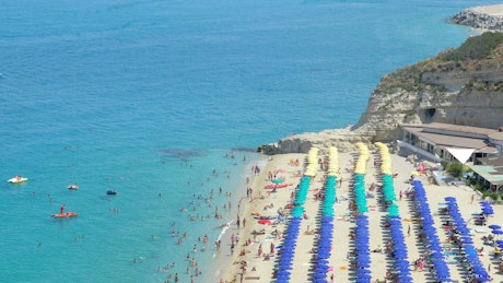 Aerial view of a popular, sunny European beach.