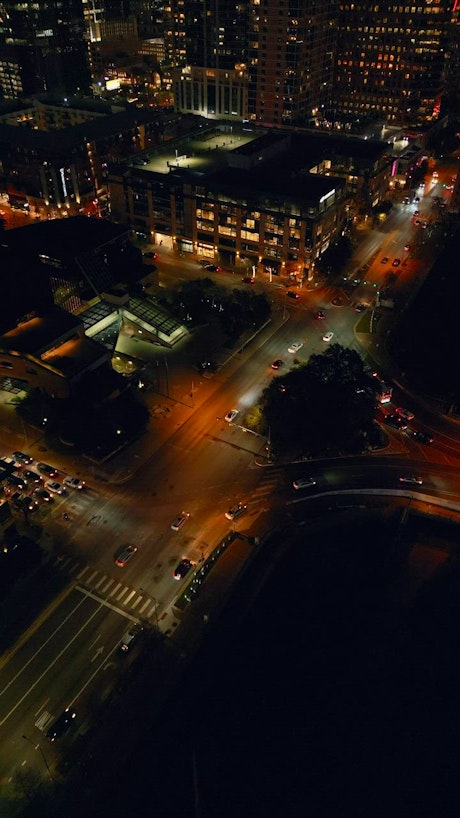 Aerial view of city roads and big iluminated city buildings at night.
