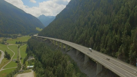 Aerial view of highway bridge along mountain ridge.