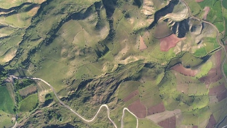 Aerial view of mountain geography, a town, and a lake.
