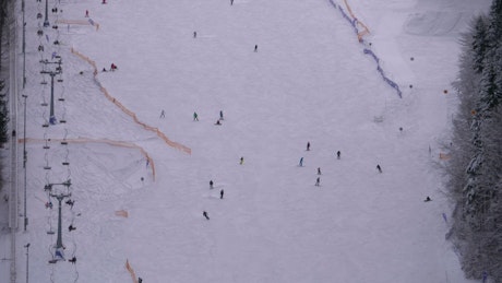 Aerial view of skiers going down the winter mountain