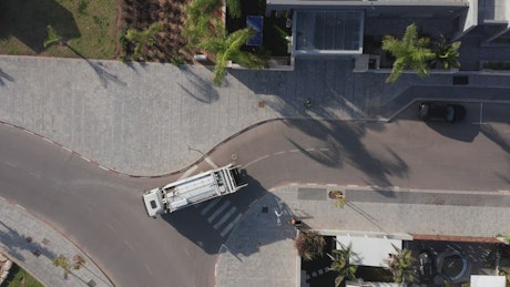 Aerial view of waste collectors removing rubbish in the early morning.