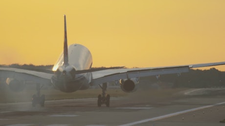 Airplane landing in slow motion in a yellow sky.