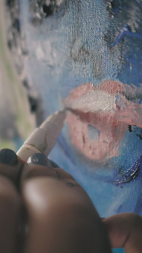 An artist's hand detailing an abstract portrait