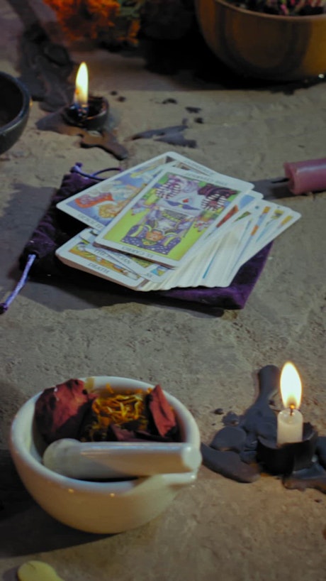 An ritual ensemble of tarot cards, candles, and an ancient knife.