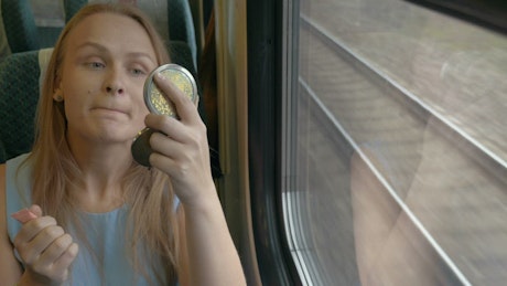 Applying makeup on a train