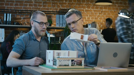 Architects checking a house model at the office