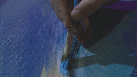 Artist brushing paint across a canvas.