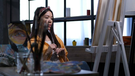 Artist looking at her painting.