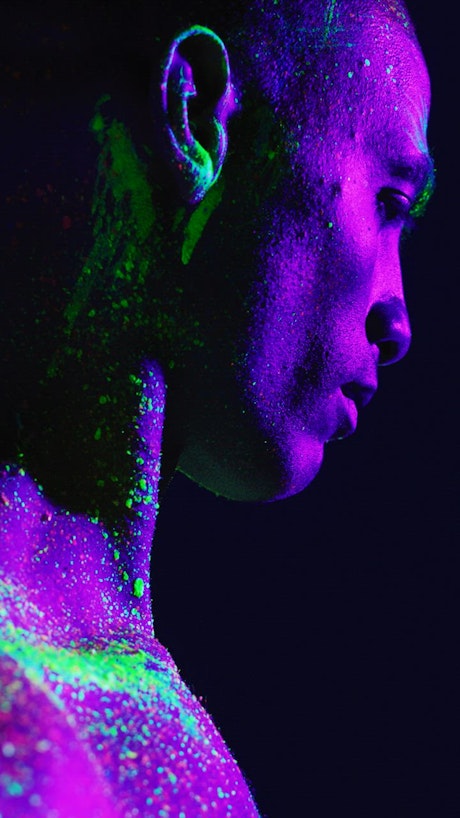 Artistic portrait of a man smeared with phosphorescent paint.