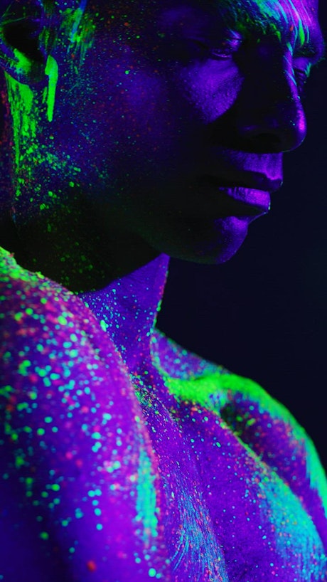 Artistic video of a man stained with phosphorescent paint.
