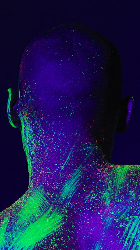 Artistic video of the back of a man stained with fluorescent.