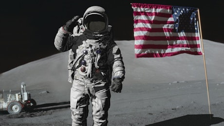 Astronaut saluting on the Moon next to the Star-Spangled banner.