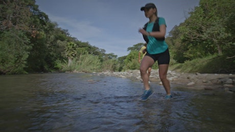 Athletic woman and a man crossing across a river.