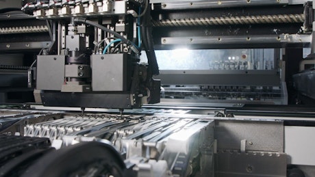 Automated machine places parts on circuit boards.