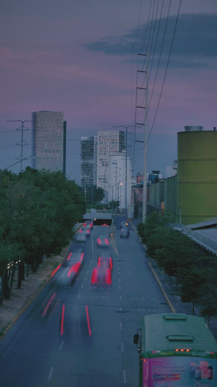 ⁣Avenue with trees, building togel 888 s and fast cars at dusk