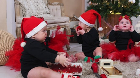 Babies playing with christmas gifts