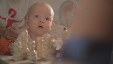 Baby girl watching a Chess game