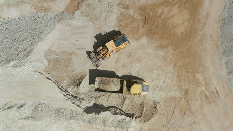Backhoe excavating dirt at a mining site.