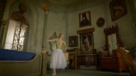 Ballerina performs classic ballet spins in a vintage decorated bedroom.