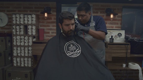 Barber cutting the hair of a male client.