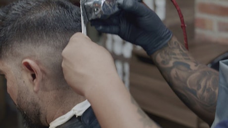 Barber doing a fashion cut to a man.