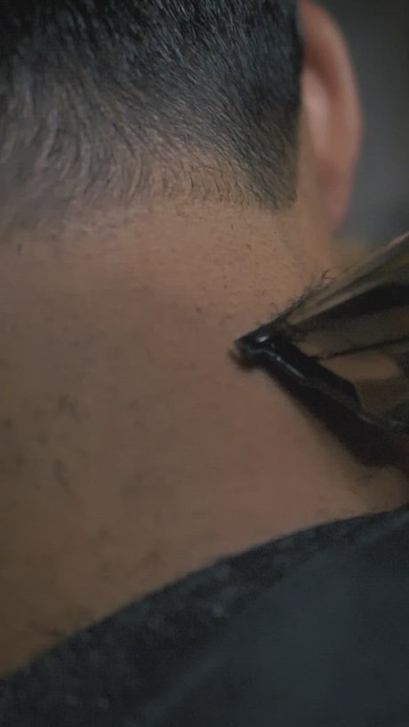 Barber outlining a man's hair with a machine