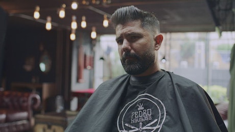Barber showing the haircut to his client