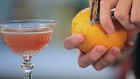 酒吧服务员正在准备一杯橙色鸡尾酒