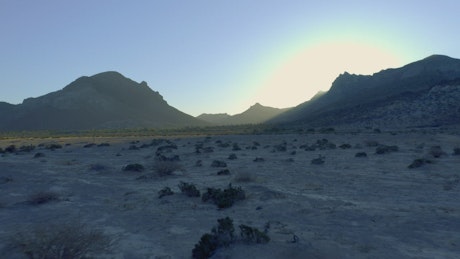 Barren landscape with mountains on a plain.