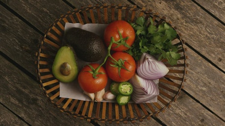 Basket of fresh avocados, tomatoes and onions.