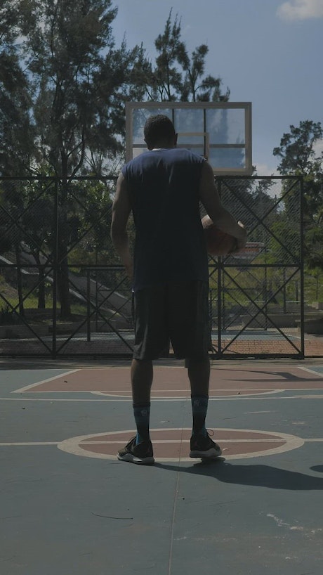 Basketball player dribbling then dunking.