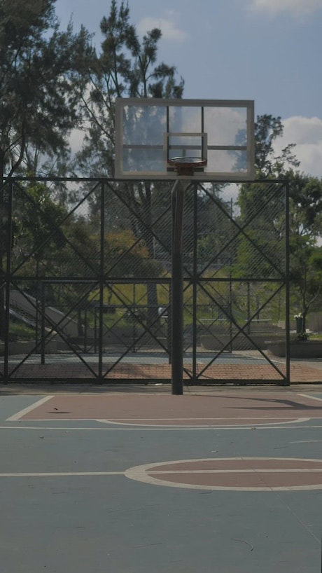 Basketballs being shot in a street rink.