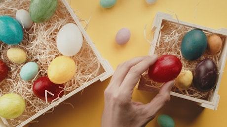 Baskets with easter eggs rotating on a yellow background.