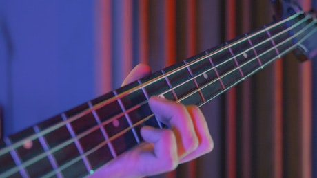 Bass player playing a song, close up view