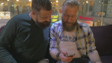 Bearded friends browsing a phone